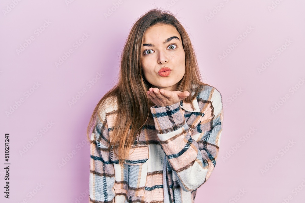 Young caucasian girl wearing casual clothes looking at the camera blowing a kiss with hand on air being lovely and sexy. love expression. Young caucasian girl wearing casual clothes looking at the camera blowing a kiss with hand on air being lovely and sexy. love expression.