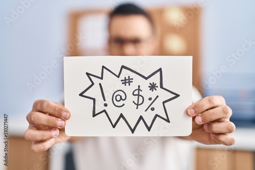 Young hispanic man business worker holding onomatopeia shout message at office