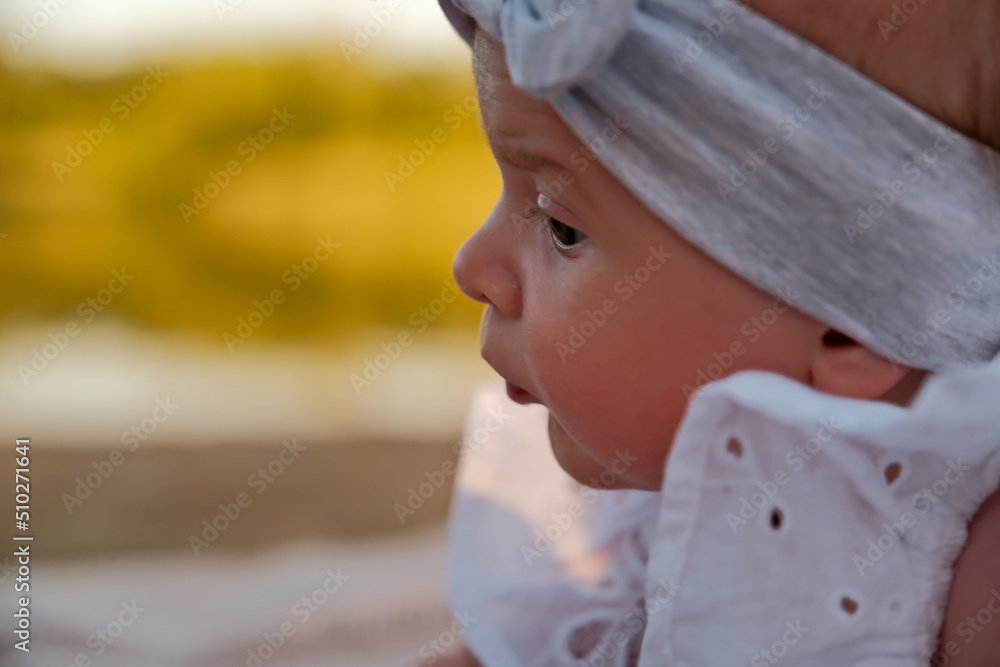newborn baby girl lies on the beach. in a white dress. newborn baby girl lies on the beach. in a white dress.