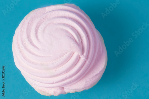 Pink marshmallow on a blue background close-up.