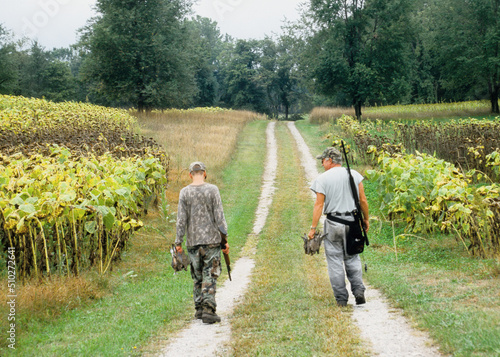 Fototapeta A pair of hunters walking after a successful dove hunt