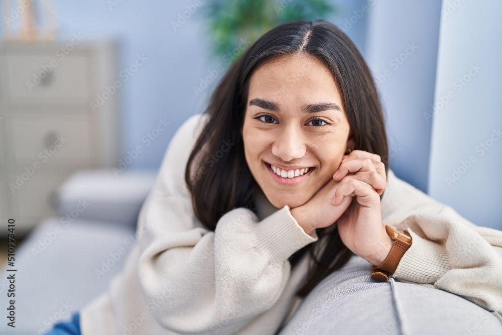 Young hispanic woman smiling confident sitting on sofa at home Young hispanic woman smiling confident sitting on sofa at home