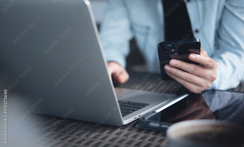 Young smart business woman using mobile phone and working on laptop computer at office. Female freelancer online working, surfing the internet at coffee shop Young smart business woman using mobile phone and working on laptop computer at office. Female freelancer online working, surfing the internet at coffee shop
