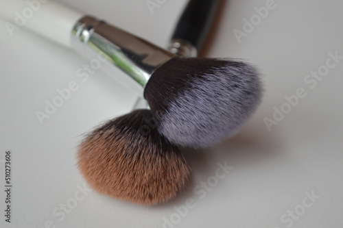 Professional cosmetic makeup brushes of different sizes on a white background for applying powder, shadows and blush and other cosmetic products