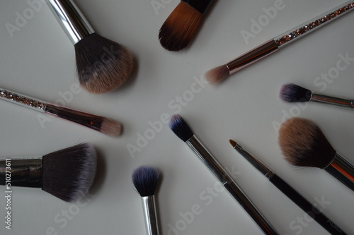 Professional cosmetic makeup brushes of different sizes on a white background for applying powder, shadows and blush and other cosmetic products