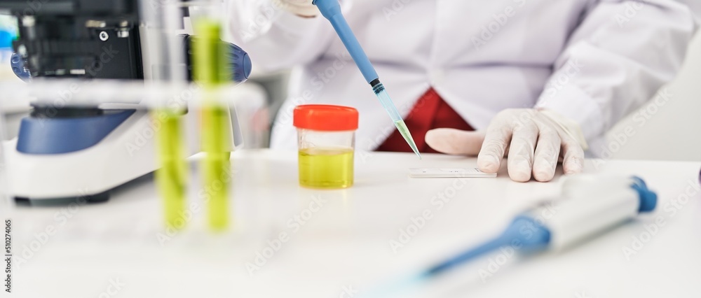 Middle age hispanic woman doing urine test at laboratory