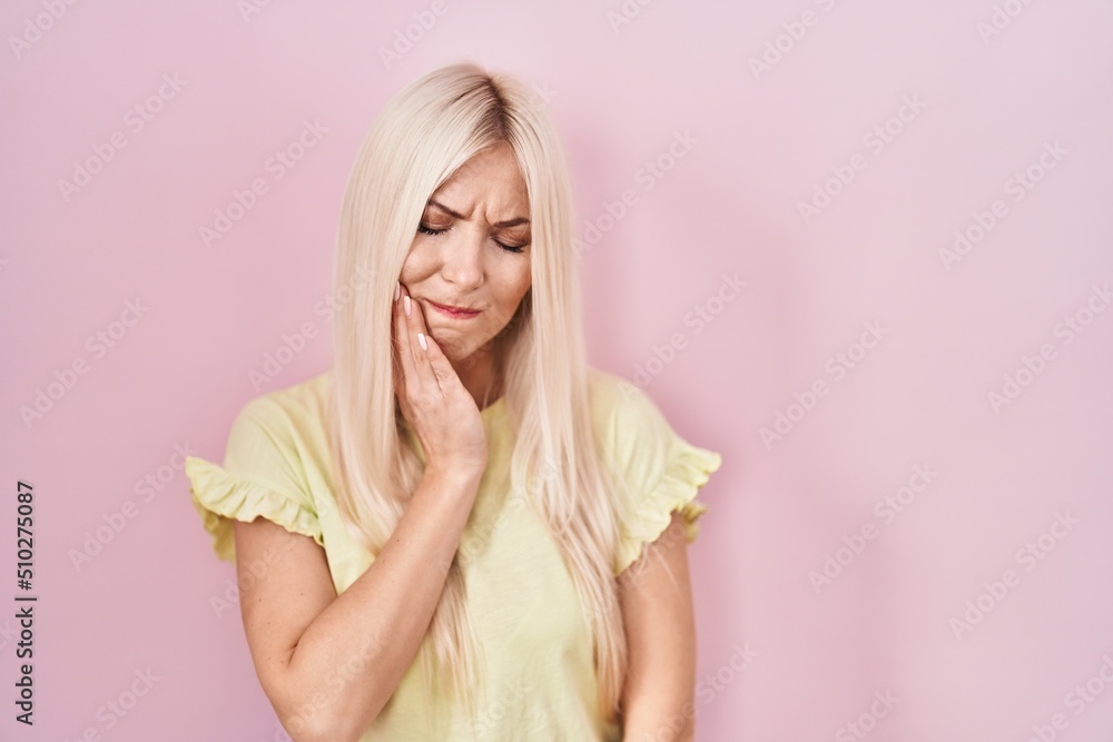 Caucasian woman standing over pink background touching mouth with hand with painful expression because of toothache or dental illness on teeth. dentist Caucasian woman standing over pink background touching mouth with hand with painful expression because of toothache or dental illness on teeth. dentist