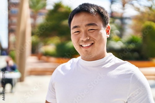 Young chinese man smiling confident standing at street