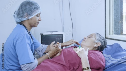 Nurse consoling elderly senior patient aftrer surgery at hsopital on bed - concept of caring, medical treatment and healthcare service photo