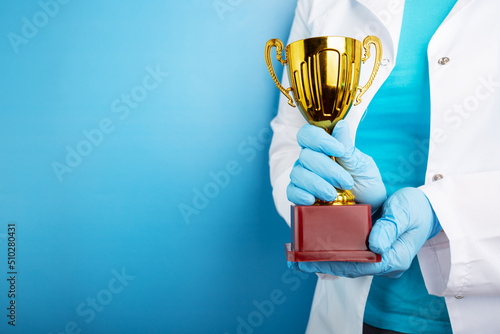 Valokuva medical award, golden cup in doctor's hands, healthcare and medicine