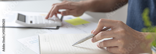 Head of accounting is recording the company's financial growth statistics using graphs as a reference for reviewing and analyzing the results, Taking notes and analyzing data graphs in office.