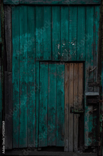 Old dark wooden rustic look barn doors. Metal hinges, and lock holders placed on the rough texture doors are very rusty.