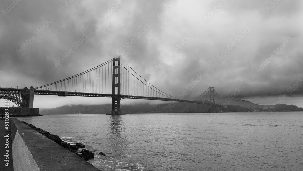 Stormy sky in a dramatic view of the famous golden gate bridge, San Francisco, USA. Monochromatic.