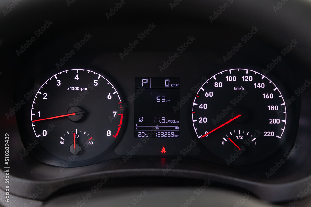 Fototapeta premium Modern car illuminated dashboard closeup. White arrows on Speedometer