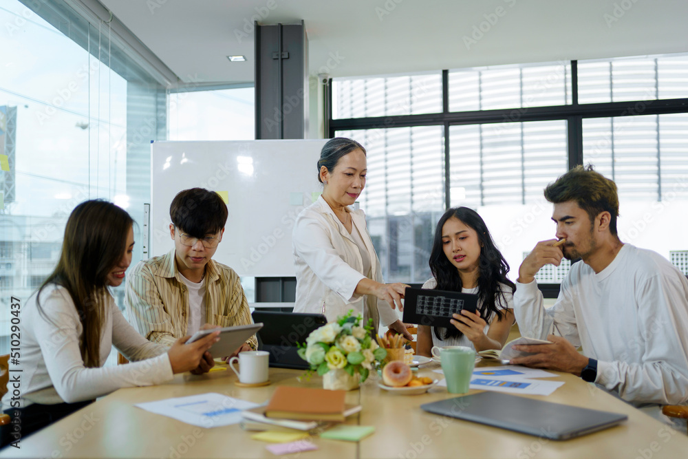 Meeting of Asian business people who are committed to work. Creative business team sitting working together at office. Meeting of Asian business people who are committed to work. Creative business team sitting working together at office.