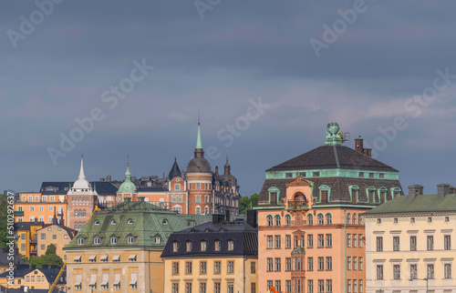 Facades, roofs and towers of 1800s houses in the old town Gamla Stan and the district Södermalm at sunrise a sunny day in Stockholm