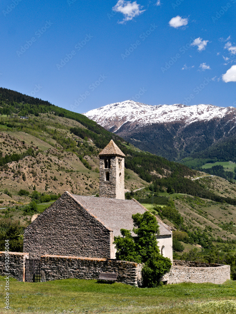 Kleine steinere Kapelle in den Alpen mit schneebedeckten Bergen im Hintergrund