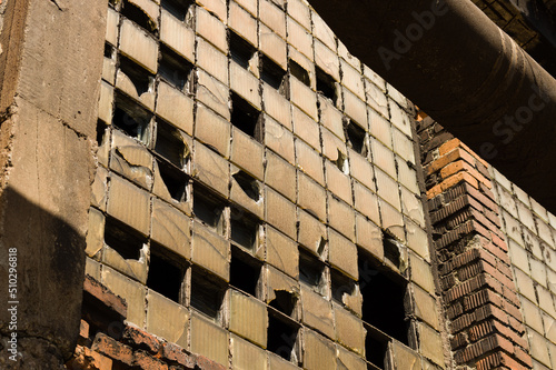 Damaged and dusty luxfers in a window of an abandoned industrial building photo