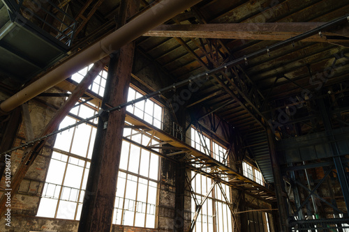 Interior of an abandoned industrial building with large glass windows