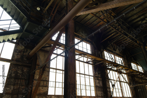 Interior of an abandoned industrial building with large glass windows © Vidu Gunaratna
