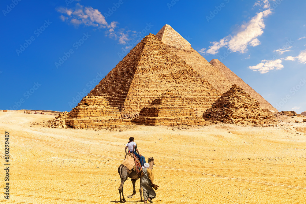 The Great Pyramid complex and bedouin with tourists in the Egypt desert, Giza