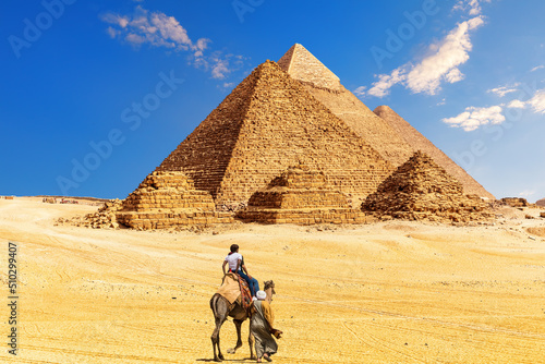 Obraz na płótnie The Great Pyramid complex and bedouin with tourists in the Egypt desert, Giza w salonie