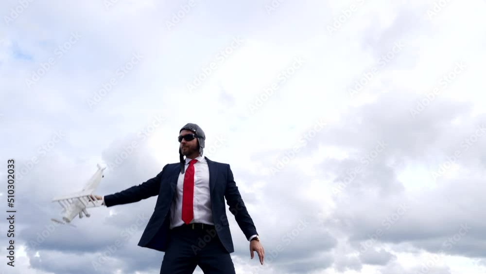 businessman in pilot hat and glasses dancing with plane on sky background, business professional. businessman in pilot hat and glasses dancing with plane on sky background, business professional.