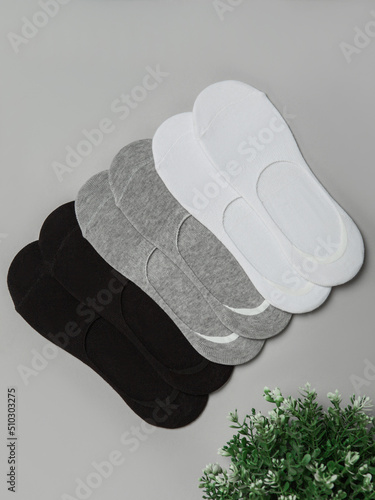 a set of socks of different colors laid out on a gray background. Comfortable footwear for ladies and girls. Cozy women's hosiery.