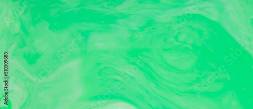 Green Fluid Art Background. Abstract liquid trendy backdrop. Different shades of green on a blurry surface