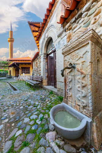 Old fountain of the Sufi temple with the minaret of Halveti’s Tekke Mosque in the background, Prizren, Kosovo photo