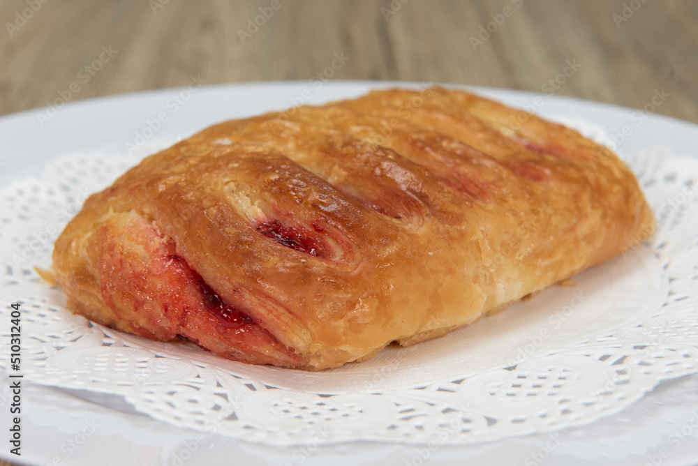 Tempting fresh from the oven chocolate croissant from the bakery served on a plate Tempting fresh from the oven chocolate croissant from the bakery served on a plate