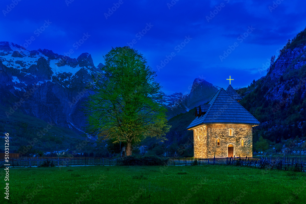 Church in the Thethi Village and snow capped mountains, at the dusk, in the Theth Valley, Albania. Church in the Thethi Village and snow capped mountains, at the dusk, in the Theth Valley, Albania.