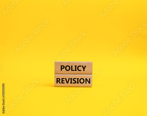 Policy revision symbol. Concept word Policy revision on wooden blocks. Beautiful yellow background. Business and Policy revision concept. Copy space