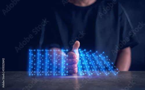 Fotografie Concept of Stop business domino failures concept, Hand of businessman stopping falling virtual blocks on table, Continuous damage reduction, Problem Solving, risk control, stopping the domino effect