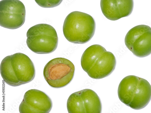 Green cherry plum on a white background. Fruit for making tkemali sauce. . Useful fruits. Sweet and sour fruit. Juicy cut green plum