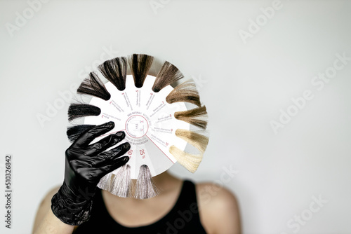 Женская рука клиента, выбирающая цвет для окрашивания волос перед окрашиванием волос в парикмахерской