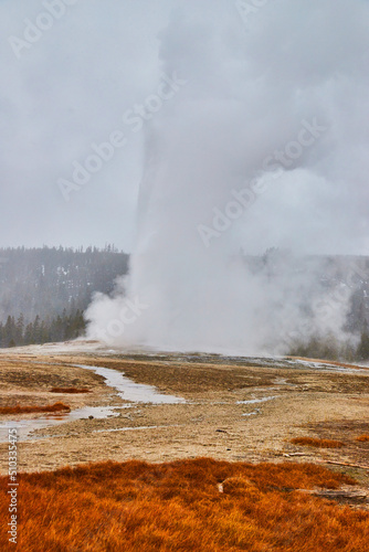 Old Faithful iconic Yellowstone geyser in winter