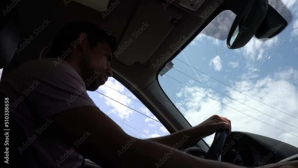 low angle view from below of the passenger seat of a man driving a car in the day with a clear and blue sky in 4k low angle view from below of the passenger seat of a man driving a car in the day with a clear and blue sky in 4k
