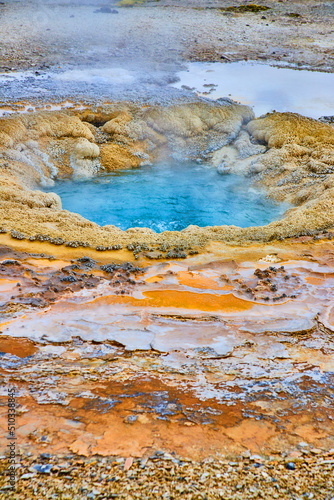 Layers of color around deep blue geyser in Yellowstone basin