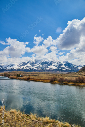 River and fields with snowy mountains and blue sky © Nicholas J. Klein
