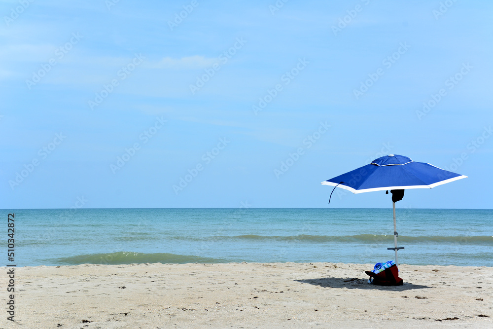 Empty beach with a single umbrella or parasol in Cocoa Beach, Florida Empty beach with a single umbrella or parasol in Cocoa Beach, Florida