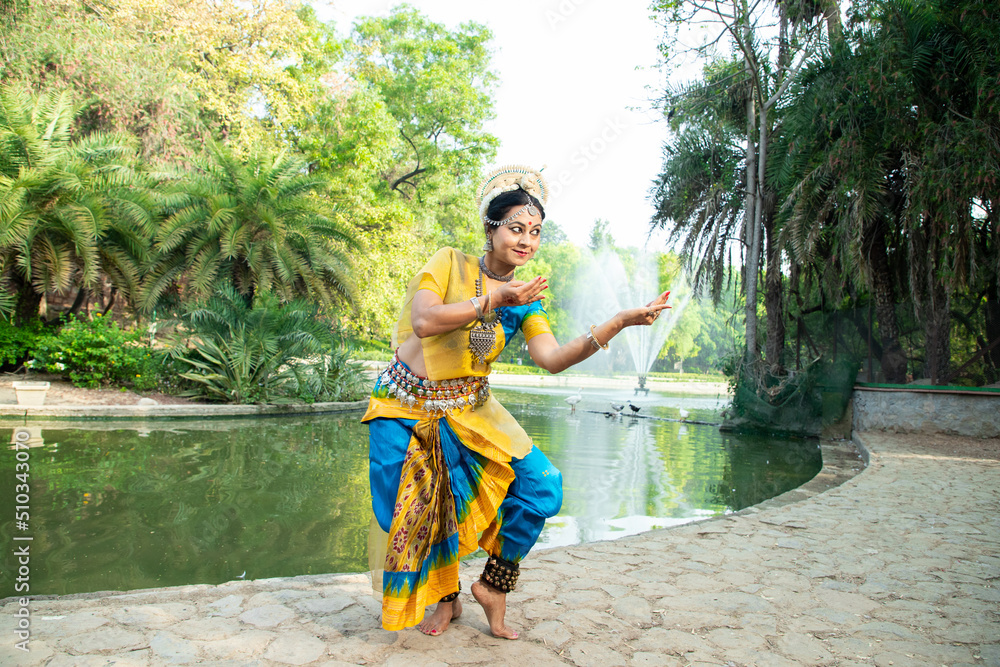 Indian woman Odissi dancer doing classical dance form outdoor at nature