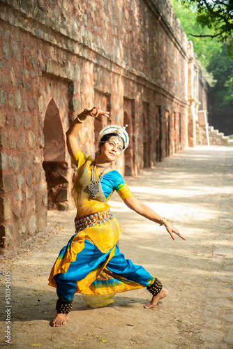 Indian woman Odissi dancer doing classical dance form outdoor at heritage place. Orissi dance. art and culture of india.