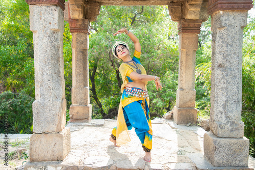 Indian woman Odissi dancer doing classical dance form outdoor at heritage place. Orissi dance. art and culture of india. closeup photo