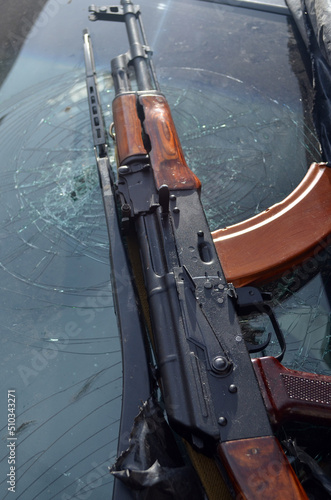 AKM(Avtomat Kalashnikova) version of Kalashnikov assault rifle and car wreck. Ukraine