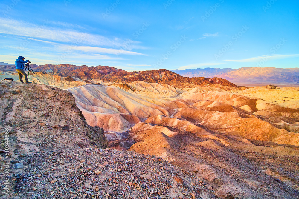 Photographer capturing stunning sunrise in majestic desert mountains of Death Valley