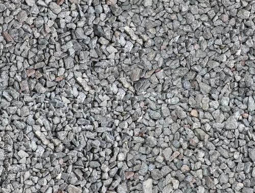 Seamless texture of the beautiful macadam. Gray, black, brown, beige, red stones are evenly scattered on the surface