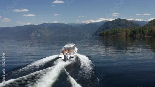 A pleasure boat goes along a picturesque lake on a sunny summer day

