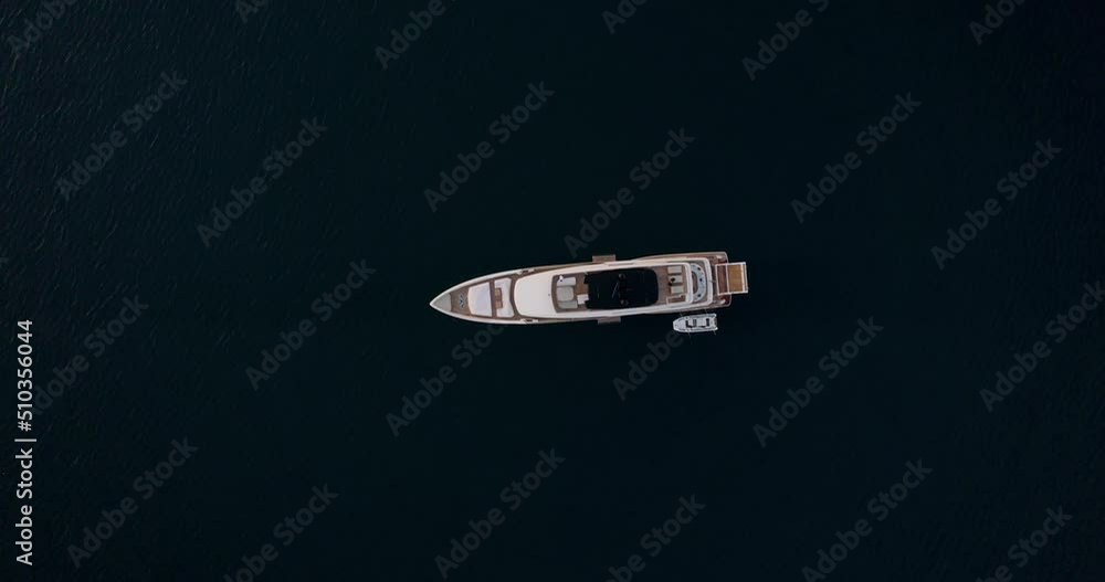 Aerial ascent over luxury yacht anchored in middle of the ocean; top-down Aerial ascent over luxury yacht anchored in middle of the ocean; top-down