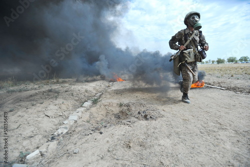 Almaty, Kazakhstan - 08.22.2012 : Soldiers pass a burning obstacle course in gas masks.